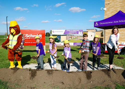 Group photo of students scooping dirt with shovels