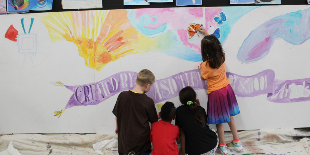 Elementary students painting mural